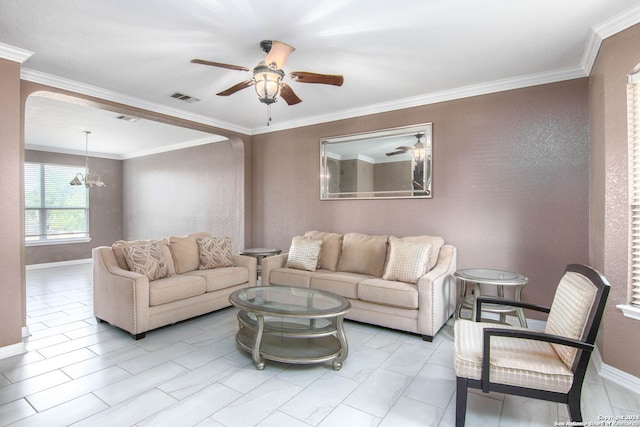 living room with ceiling fan with notable chandelier and ornamental molding