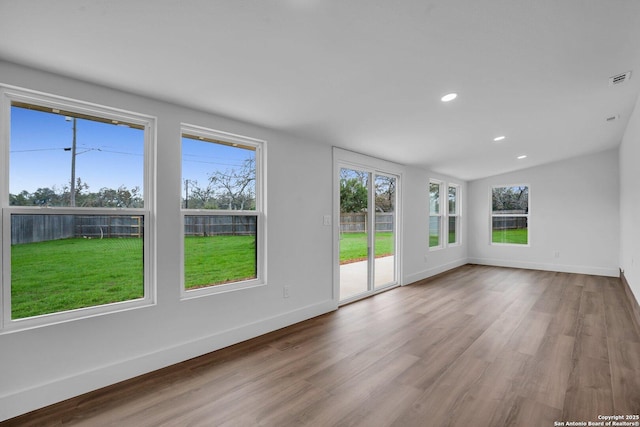 spare room with vaulted ceiling and light hardwood / wood-style floors