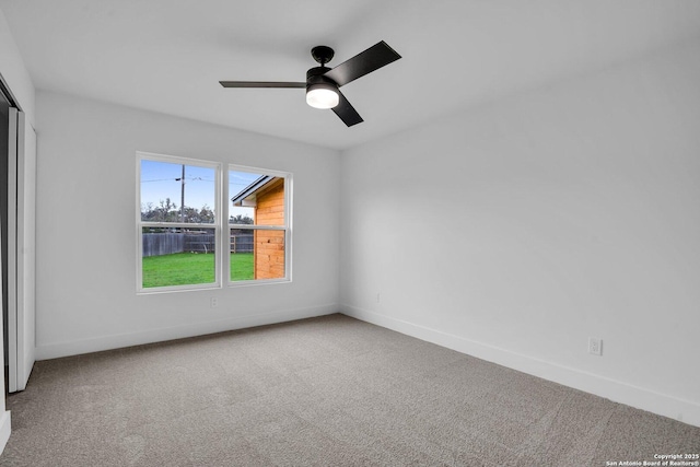 carpeted spare room with ceiling fan