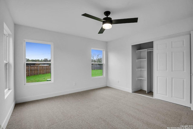 unfurnished bedroom featuring ceiling fan, light colored carpet, and a closet