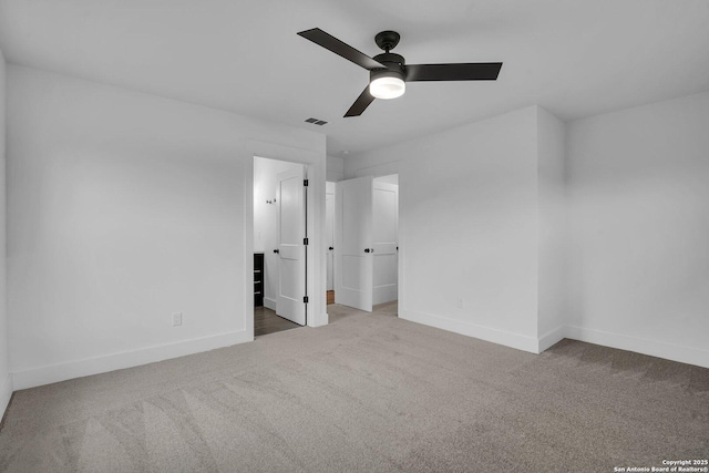 unfurnished bedroom with ensuite bath, carpet floors, and ceiling fan