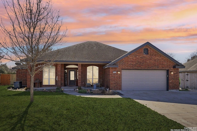 ranch-style home with a garage and a yard