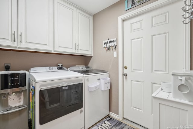 clothes washing area featuring cabinets and separate washer and dryer