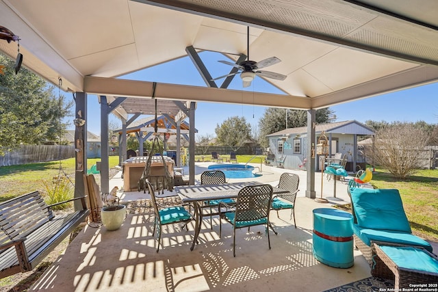 view of patio / terrace with a fenced in pool, an outdoor bar, ceiling fan, a gazebo, and an outdoor structure