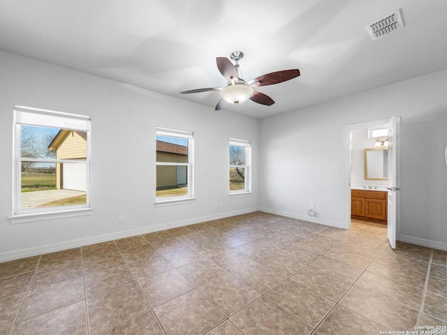 unfurnished bedroom featuring ceiling fan, ensuite bathroom, and light tile patterned floors