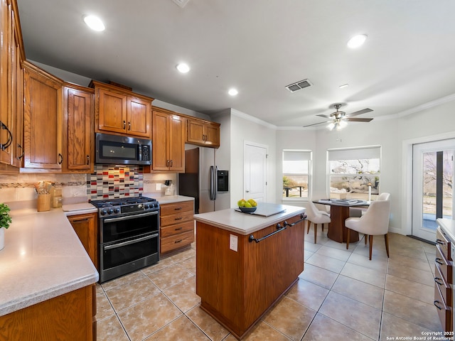 kitchen featuring ornamental molding, appliances with stainless steel finishes, a center island, and backsplash