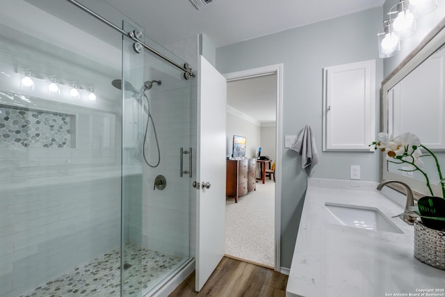 bathroom with an enclosed shower, vanity, and hardwood / wood-style flooring