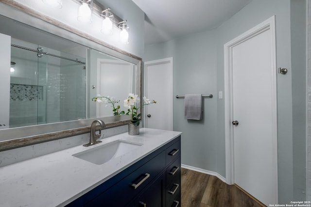 bathroom with vanity, wood-type flooring, and a shower with door