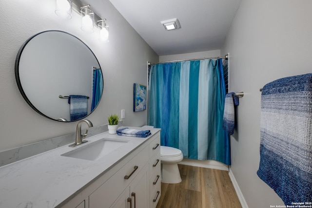 bathroom featuring wood-type flooring, toilet, a shower with shower curtain, and vanity