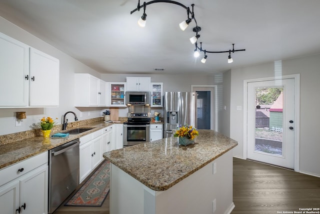 kitchen featuring stainless steel appliances, white cabinetry, sink, and light stone counters