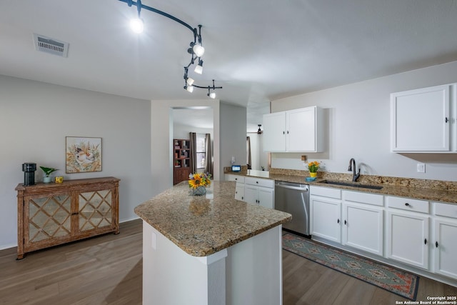 kitchen with white cabinetry, stainless steel dishwasher, sink, and light stone counters