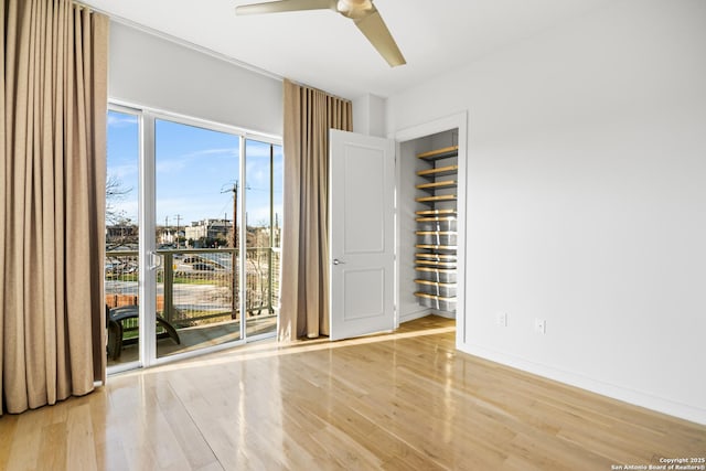 spare room featuring a ceiling fan, baseboards, and wood finished floors