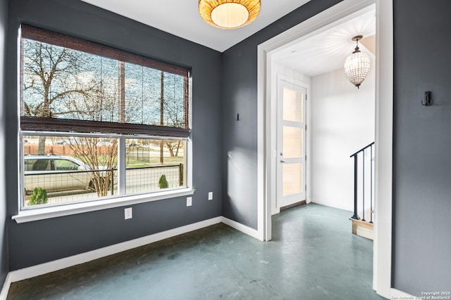 spare room with concrete floors and baseboards