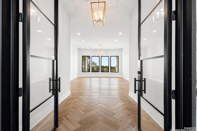 entryway featuring light parquet floors and an inviting chandelier