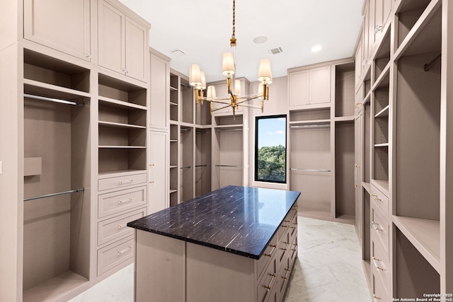 walk in closet with an inviting chandelier