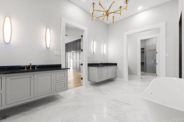 bathroom featuring a washtub, vanity, and a notable chandelier