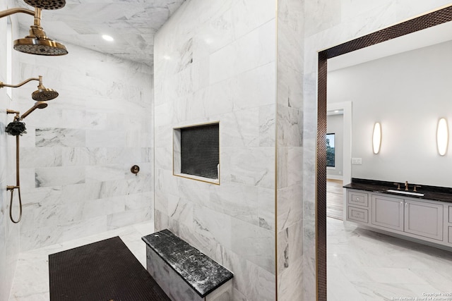 bathroom with vanity and a tile shower