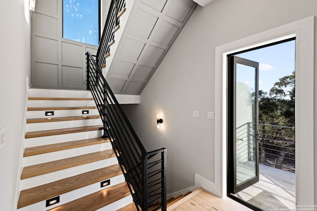 stairs featuring hardwood / wood-style floors and vaulted ceiling