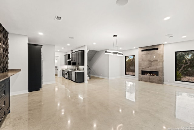 living room featuring a tile fireplace and sink