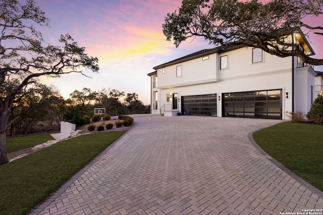 view of front of home with a garage and a lawn