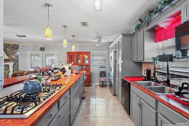 kitchen featuring pendant lighting, gray cabinetry, wooden counters, light tile patterned floors, and black appliances