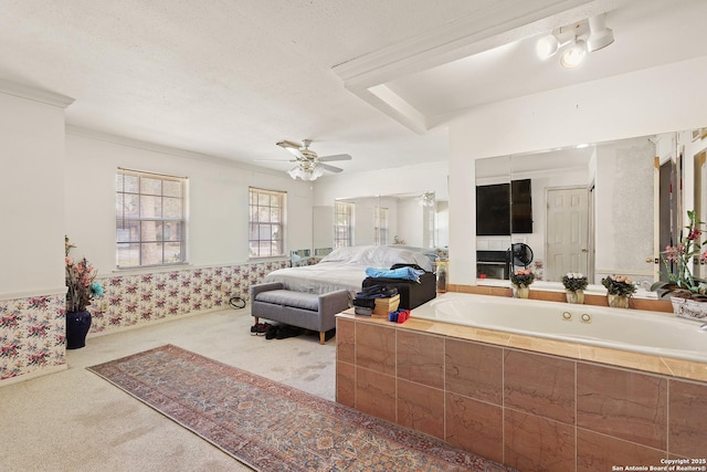 carpeted bedroom featuring a textured ceiling, ornamental molding, and ceiling fan