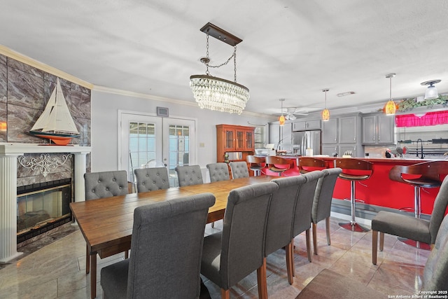 dining space with ornamental molding, light tile patterned floors, a fireplace, and french doors