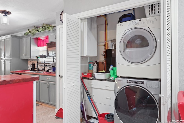 washroom with light tile patterned flooring and stacked washer and clothes dryer