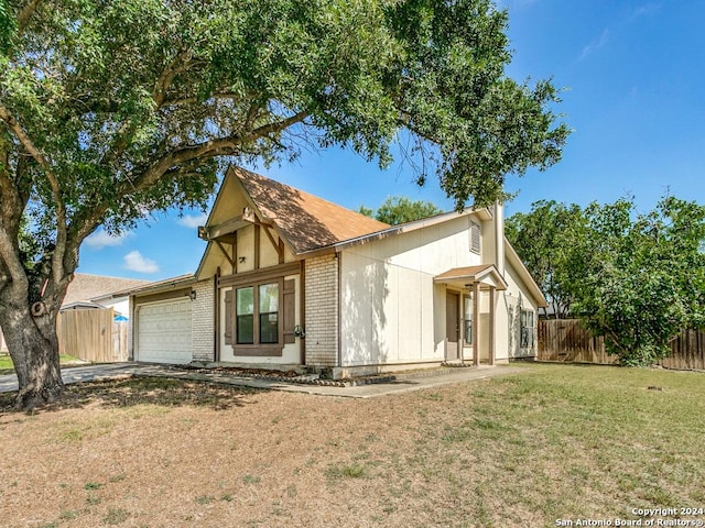 back of property featuring a garage and a lawn