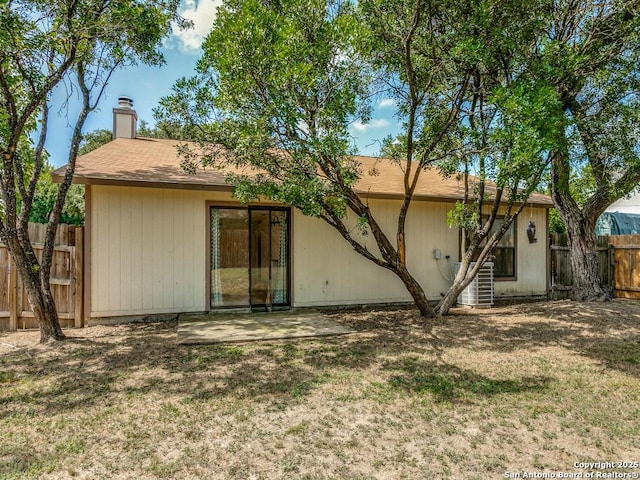 back of house with a yard and central AC unit