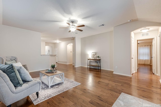 living room with hardwood / wood-style flooring, vaulted ceiling, and ceiling fan