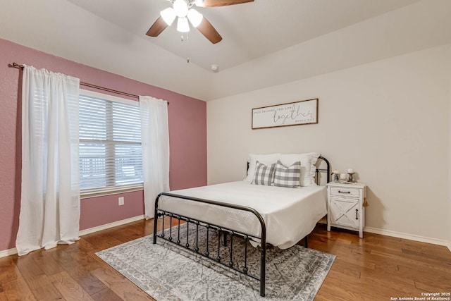 bedroom featuring wood-type flooring, vaulted ceiling, and ceiling fan