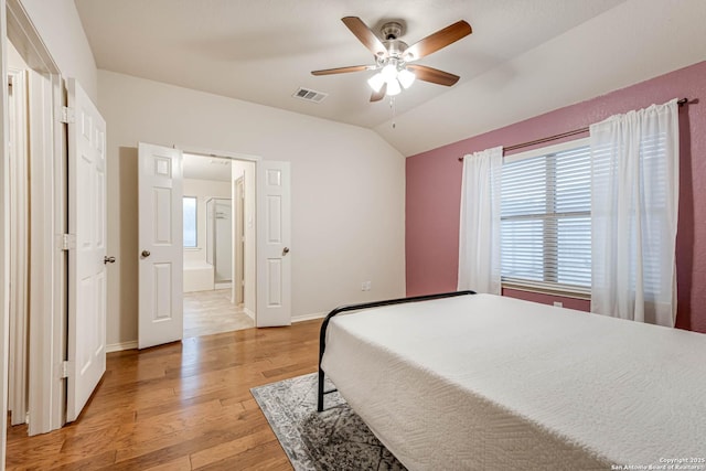 bedroom featuring vaulted ceiling, connected bathroom, ceiling fan, and light hardwood / wood-style flooring