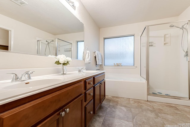 bathroom with vanity, a textured ceiling, and separate shower and tub