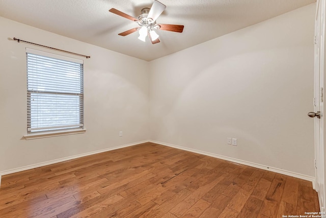 spare room featuring wood-type flooring, a textured ceiling, and ceiling fan