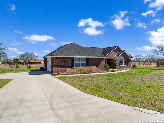 single story home featuring concrete driveway, brick siding, roof with shingles, and a front yard