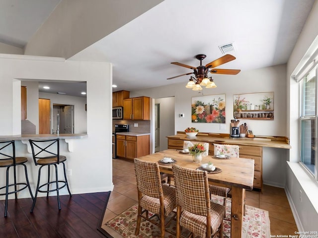 tiled dining space with ceiling fan