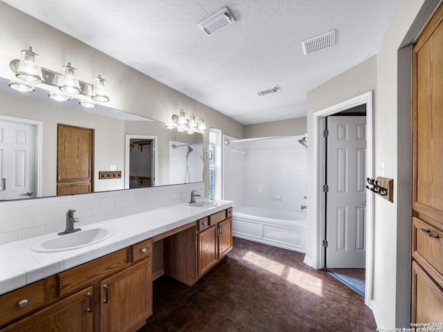 bathroom featuring tiled shower / bath combo, tasteful backsplash, vanity, and a textured ceiling