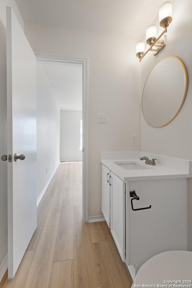 bathroom featuring vanity, wood-type flooring, and toilet