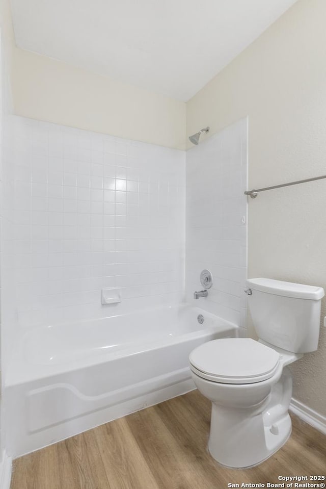 bathroom with hardwood / wood-style flooring, toilet, and shower / bathing tub combination