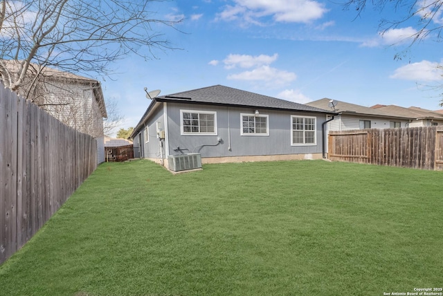 back of house with a lawn and central air condition unit