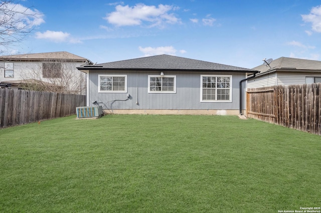 back of property with central AC unit and a lawn