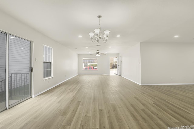 interior space featuring ceiling fan with notable chandelier and light wood-type flooring