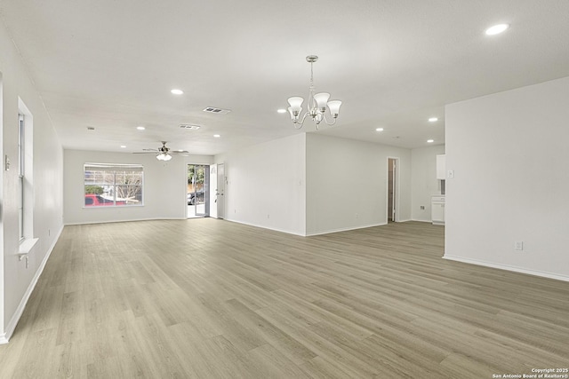 unfurnished living room with ceiling fan with notable chandelier and light hardwood / wood-style flooring