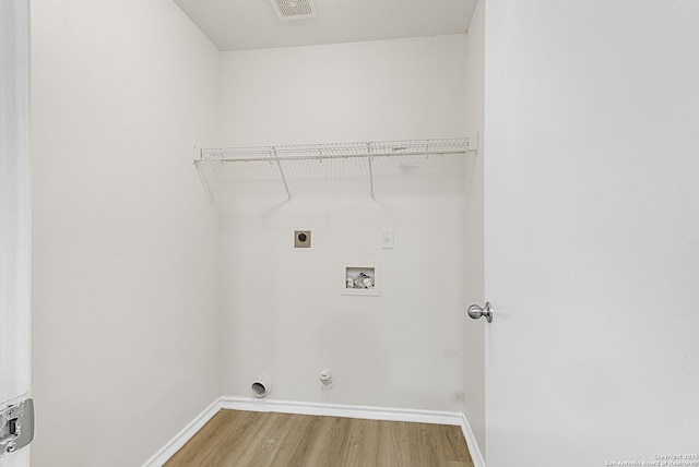 laundry room with hardwood / wood-style flooring, gas dryer hookup, hookup for an electric dryer, and hookup for a washing machine