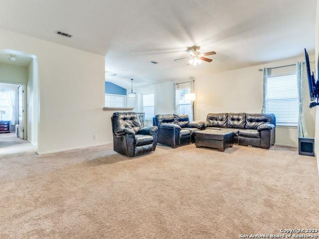 living room featuring ceiling fan, lofted ceiling, and light carpet