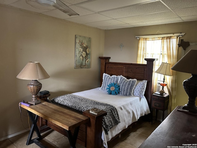 bedroom featuring a paneled ceiling and tile patterned flooring