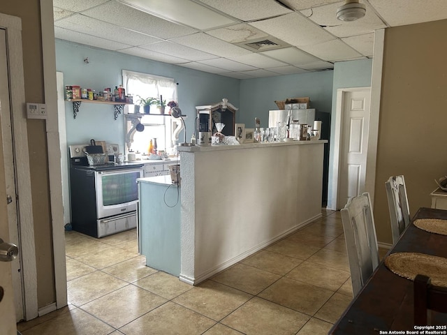 kitchen featuring a paneled ceiling, stainless steel appliances, kitchen peninsula, and light tile patterned floors