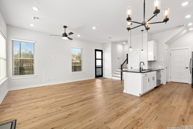 kitchen featuring stainless steel dishwasher, sink, pendant lighting, and white cabinets