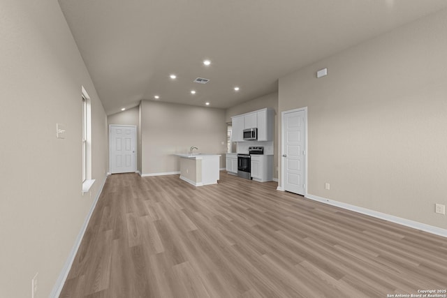 4237 Carlotta Dr, New Braunfels, TX 78130 - unfurnished living room featuring light wood finished floors, visible vents, lofted ceiling, and baseboards